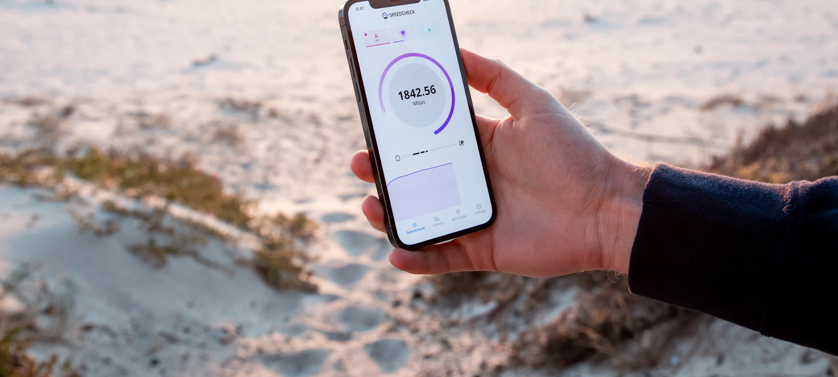 Hand holding a phone showing a fitness progress screen