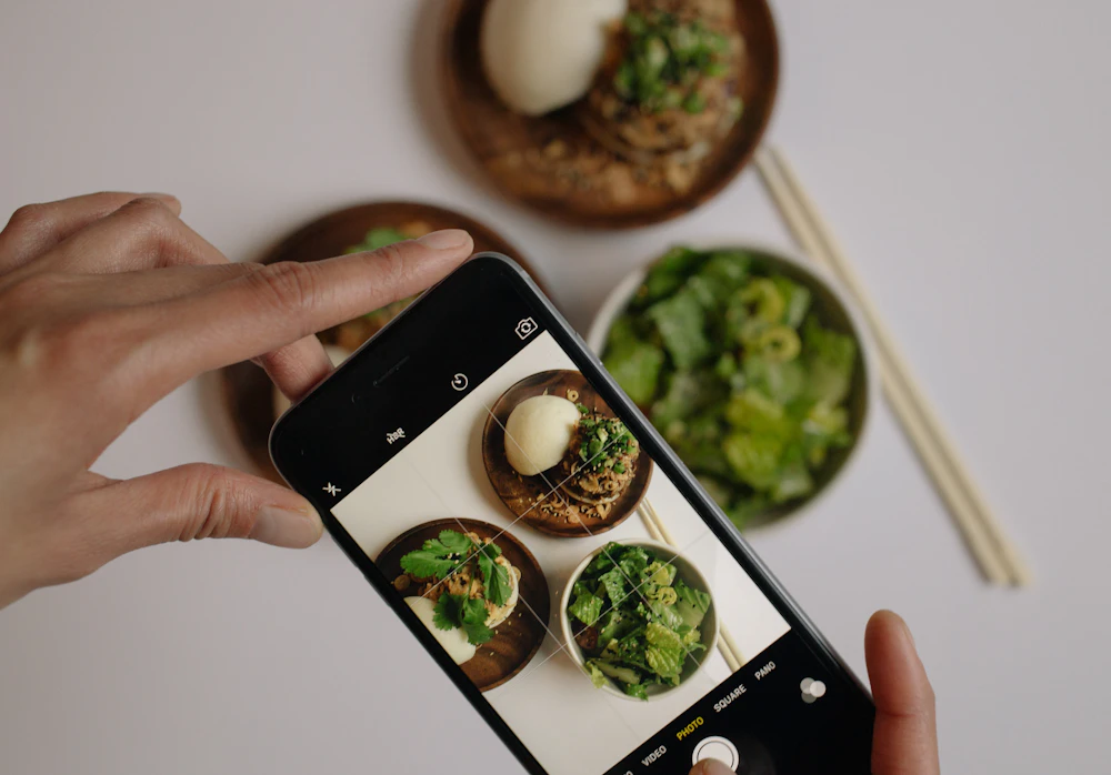 Person photographing a dish with a smartphone