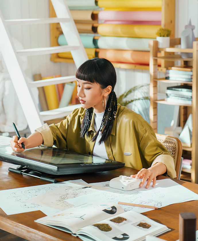 Graphic designer working on a digital tablet in her studio