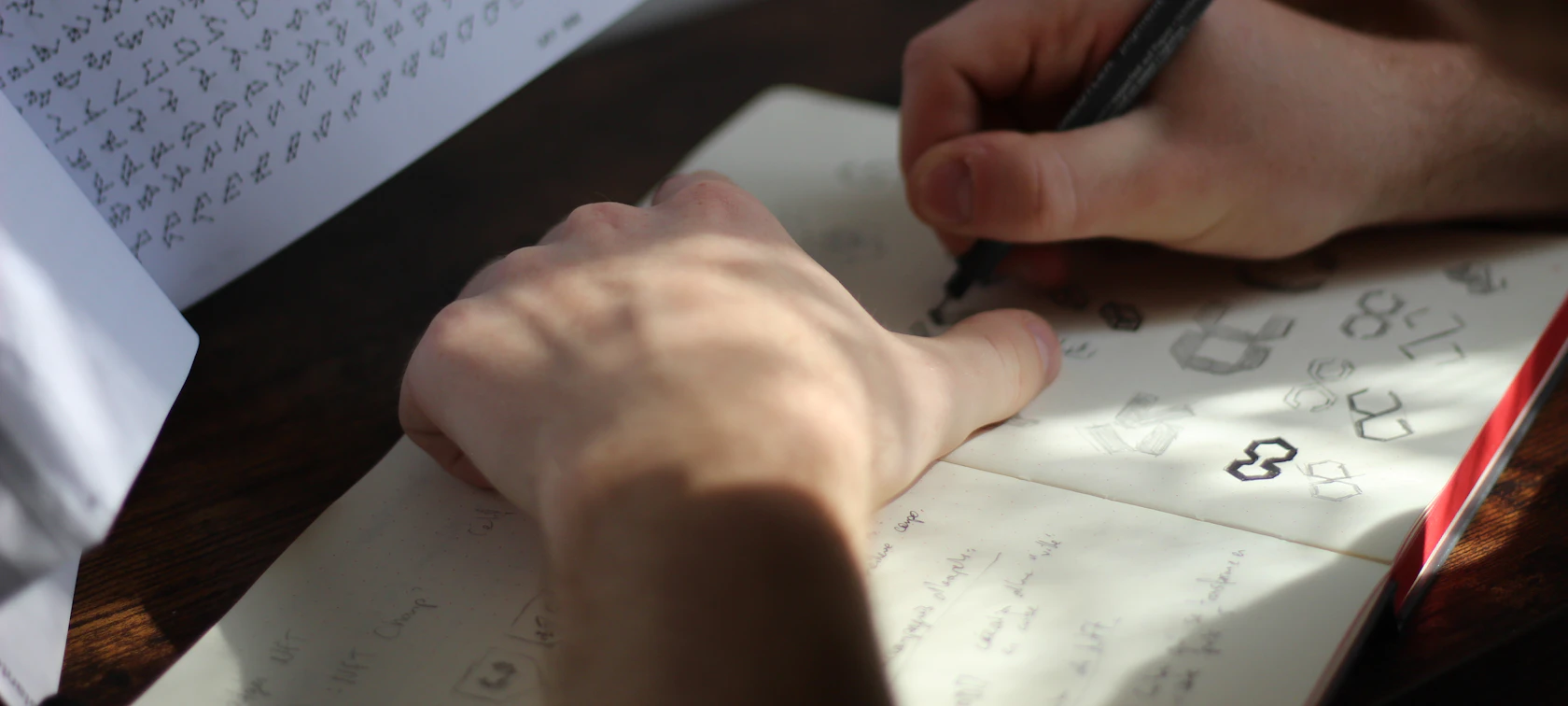 Designer sketching logo concepts on paper