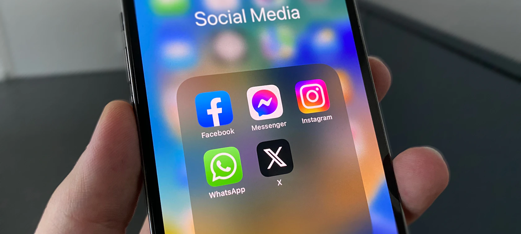 Hand holding a smartphone showing social media apps