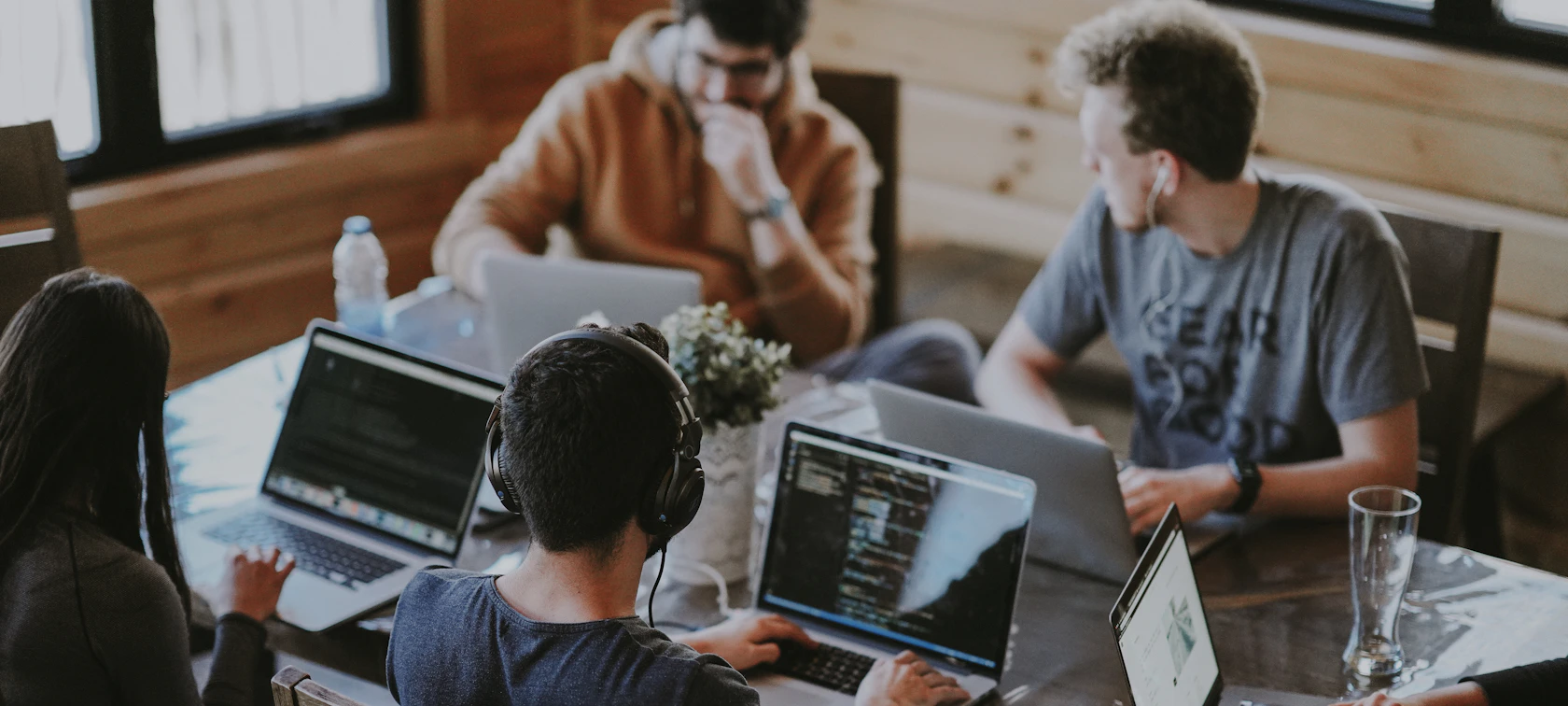 Software development team working on laptops around a table