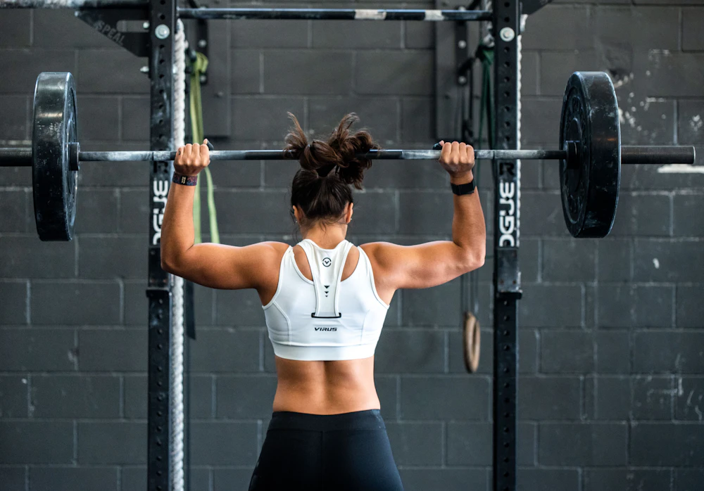 Woman lifting a barbell in a gym